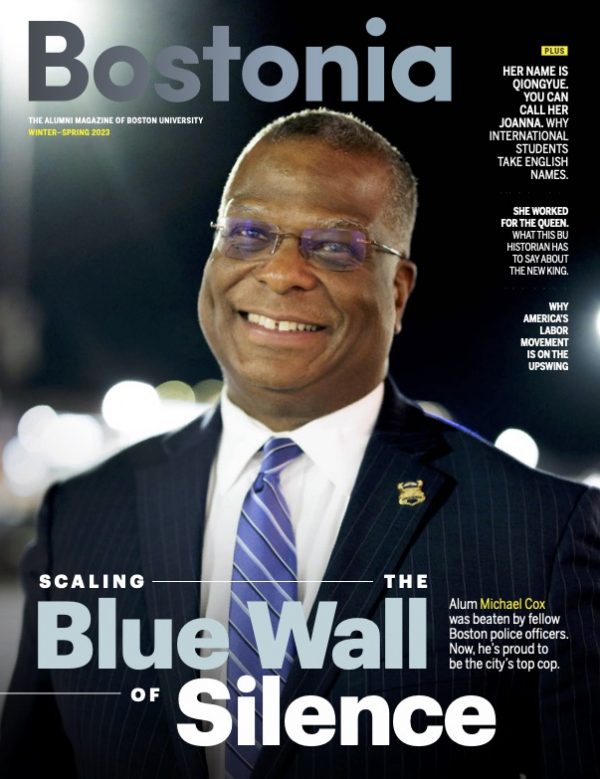 Image: cover of the Bostonia magazine winter-Spring 2023 issue. A photo of Boston Commissioner Michael Cox is shown on the right. Photo of Boston police commissioner Michael is front and center. A Black man wearing glasses, a navy blue suit and blue striped tie, smiles as he looks to the distant left. Large text reads "Bostonia, Scaling the Blue Wall of Silence" and features the headlines of other features images to the lower righthand side in smaller font.