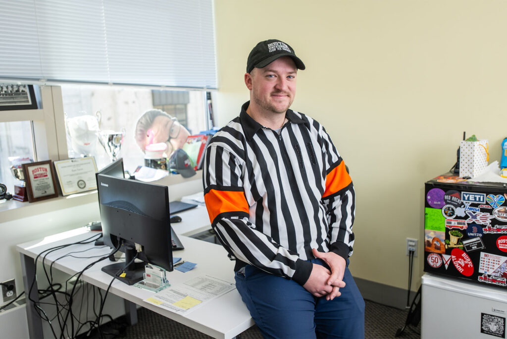 Photo: A man in a referee outfit with a hat and a long-sleeved shirt with vertical black and white stripes