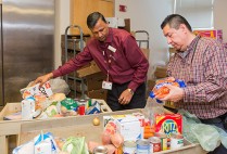 Latchman Hiralall, manager of Boston Medical Center’s Preventive Food Pantry (left), and food pantry assistant Juan Carlos Turcios prepare a cart of food for a patient. Photos by Dana J. Quigley