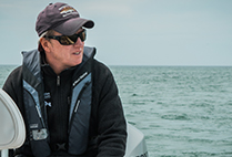 Greg Skomal, Atlantic White Shark Conservancy shark researcher sitting on a boat during an expedition to track Cape Cod sharks