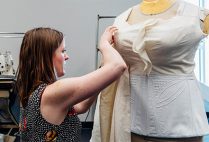 A theatre student working in the Boston University College of Fine Arts costume shop works tailoring a women's costume for the stage production of Angels in America.