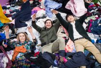 Students playfully toss cloths at the camera in the garment district