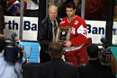 Former Northeastern goaltender Dan Eberly presents the Eberly Award to Sean Fields (CAS'04) following BU's 2-1 overtime loss to Boston College in the Beanpot tournament championship on February 9. The award, named after Dan and his brother, former BU goalie Glen Eberly (COM'63), is given annually to the goaltender with the tournament's best save percentage. Fields won not only consecutive Eberly awards, but also his second straight Beanpot MVP trophy. Photo by Albert L'Étoile 