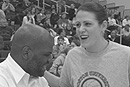 Terrier women's basketball guard Katie Terhune (CAS'04) was the winner in a mock shootout competition on February 26 with Kenneth Elmore, dean of students, during halftime of a men's basketball game at the Roof. The previous night, despite the team's two-point loss at Stony Brook University, Terhune had become BU's all-time leading scorer, surpassing the record of 1,869 points set by Debbie Miller-Palmore (SED'81). Terhune finished the 200304 regular season with 1,932 points. She will continue to add to her career total when BU goes for the America East Friendship Cottage Cheese Championship, which began March 11. Photo by Fred Sway 
