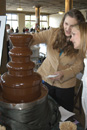Leanne Palmer, a BU culinary arts student, and Devon Harrison experiment with the chocolate fountain at the New England Chocolate Festival. Photo by Albert LEtoile