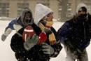 Three feet high and rising. Snowflakes and swirling winds were battering the Charles River Campus on January 23, when these students gathered at Alpert Mall for a cold game of football. Photo by Kalman Zabarsky.