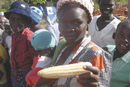 A Zimbabwean farmer holding a type of maize recently introduced to the country. Photo by James McCann