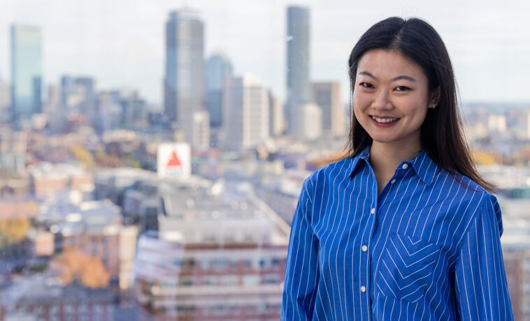 Sejin Paik smiling portrait with Boston skyline in background.