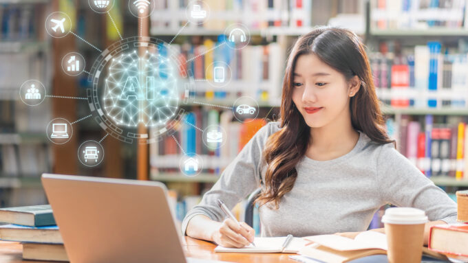 In a library, a young woman is studying with a laptop open in front of her. An AI graphic appears above the computer.