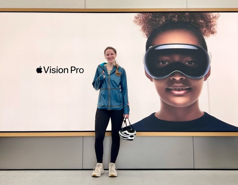Brynna Freitag with a poster of th eApple Vision Pro