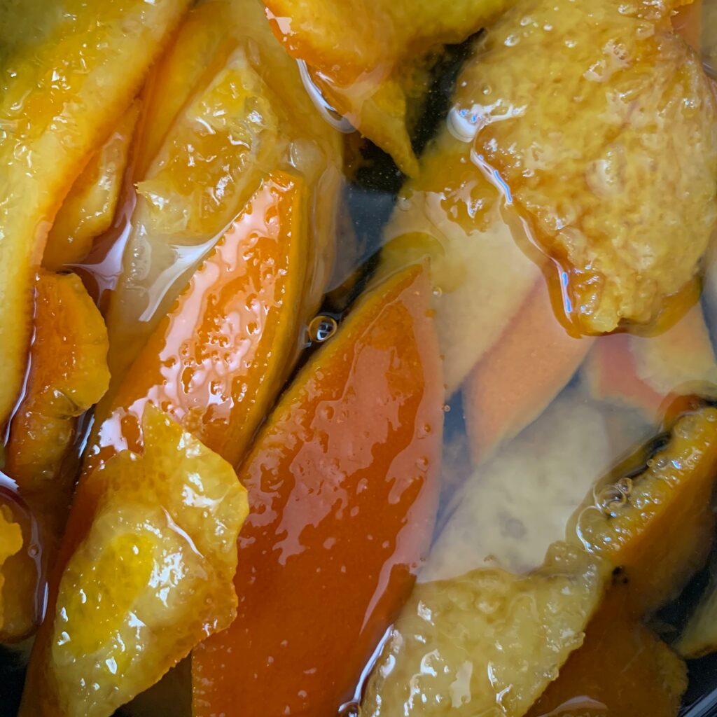 Photo of orange peels simmering in simple syrup.