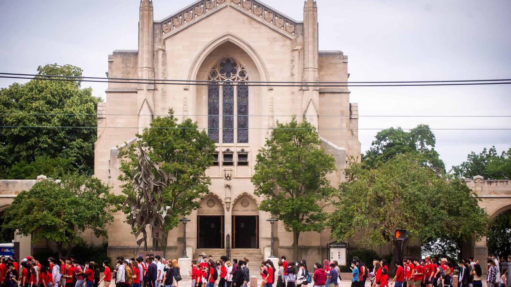 Members of the Boston University Class of 2025 walk past Marsh Chapel on Commonwealth Ave towards their Matriculation Ceremony at Agganis Arena.