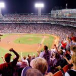 Photo: A wide shot of fans cheering at a game at Fenway stadium.