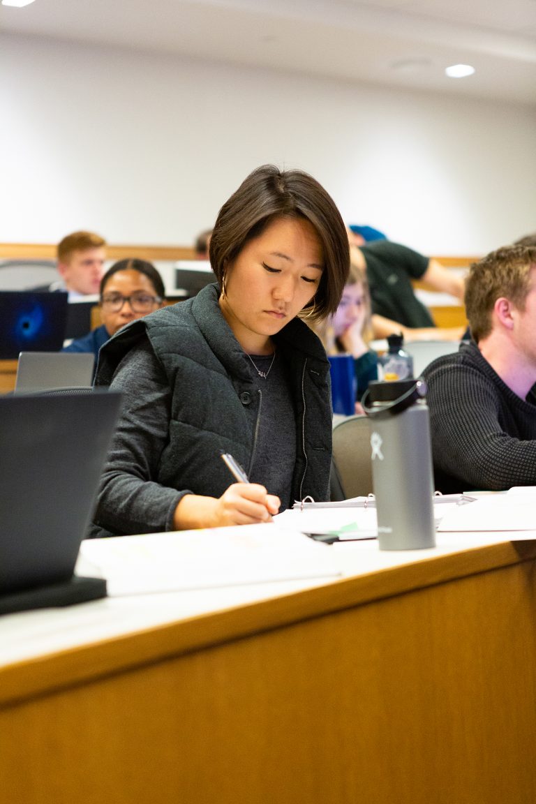 A student takes notes in a classroom in the Redstone building in 2019