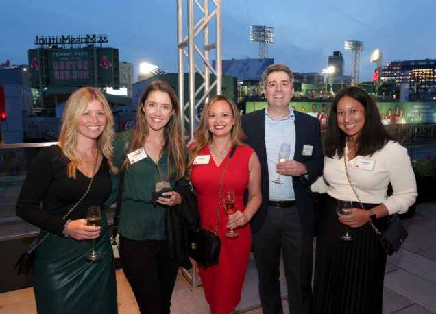 A group of alumni celebrate their Reunion with Fenway Park in the background