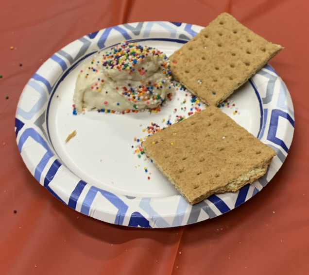 To depict the dip topped with sprinkles along side graham crackers
