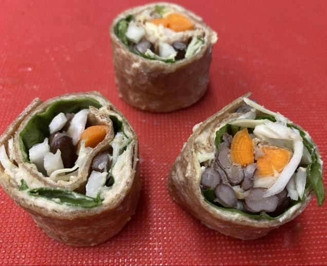 To show the veggie and hummus filling inside the veggie roll ups.