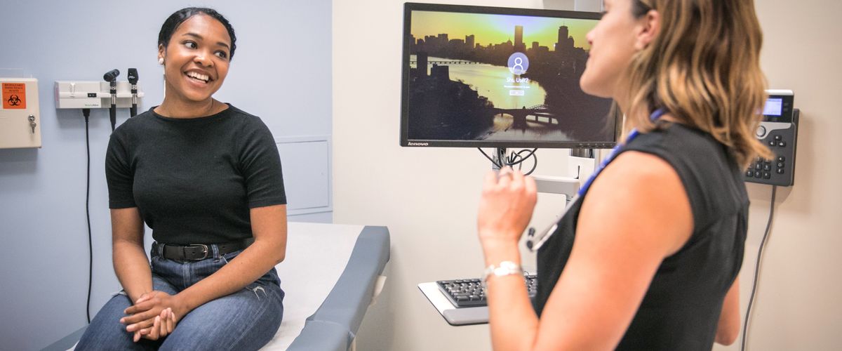 Student talking to physician in exam room