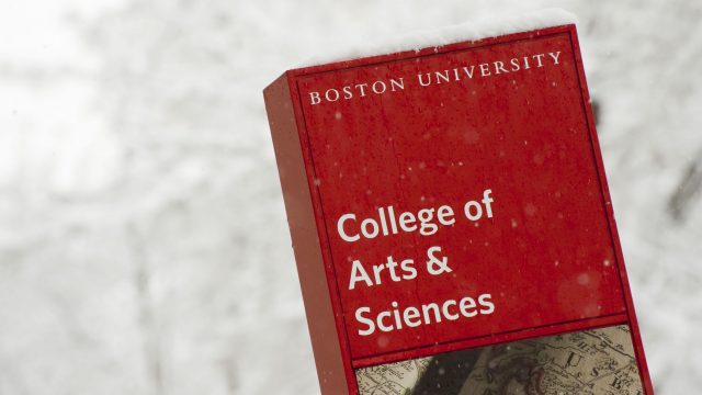 A sign that says "College of Arts & Sciences" and it is snowing