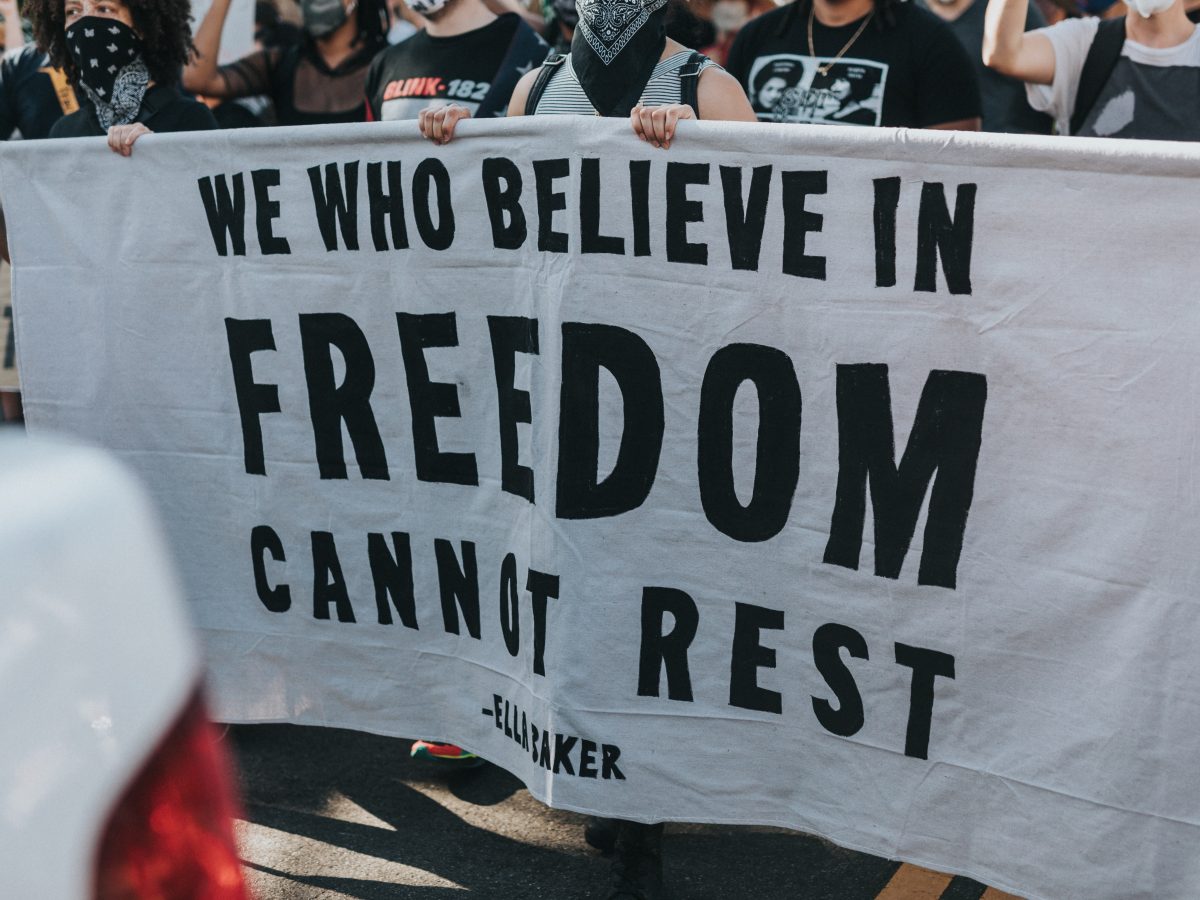 protesters-hold-banner-we-who-believe-in-freedom-cannot-rest