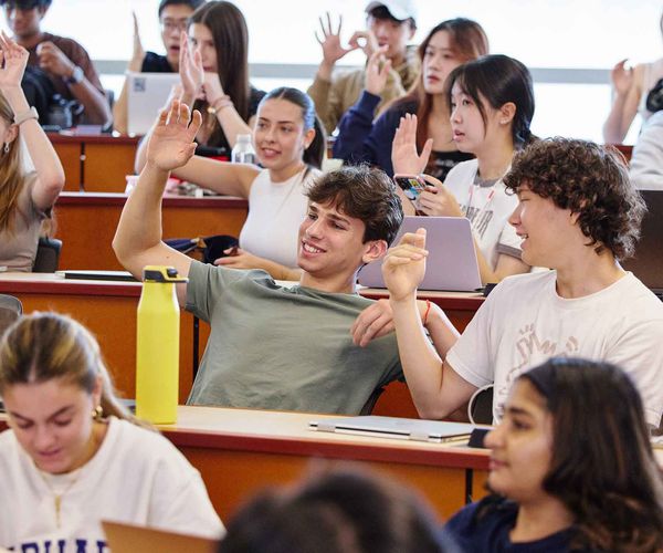 A student raising his hand in a Boston University Summer Term class