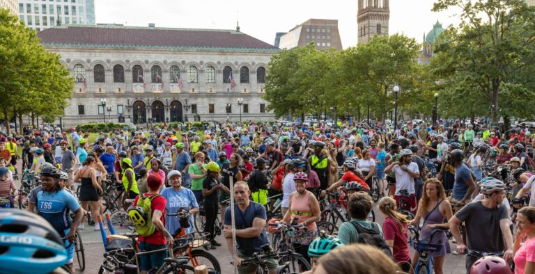 Large, colorful group of people on bikes in Copley Square