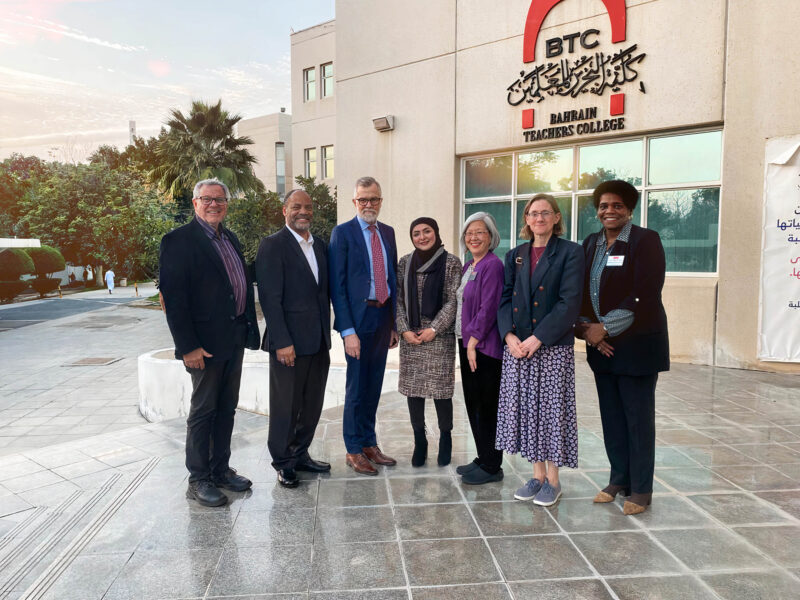 (From left) Robert Weintraub, Stacy Scott, Dean David Chard, BTC Acting Dean Masooma Almutawah, Lisa Ijiri, Lucy Bailey, and Pipier Smith-Mumford gather in front of the Bahrain Teachers College in January.