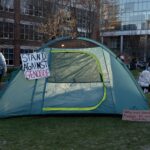 Photo: A picture of a tent with a sign on it that says "Stand Against Genocide."