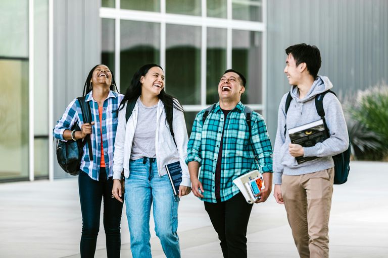 Four students walk and talk together