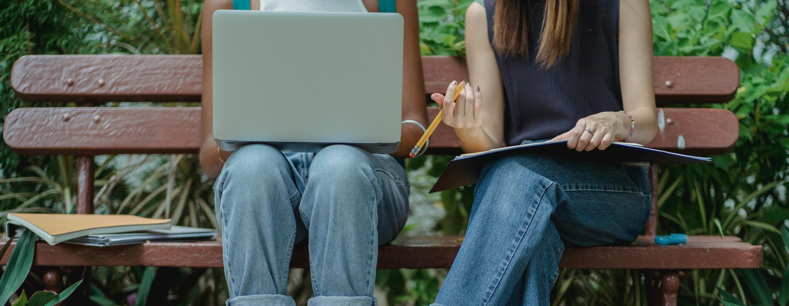 Two students on a bench studying