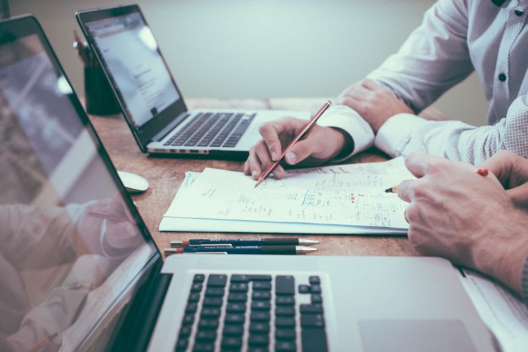 A desk with someone editing notes on a piece of paper