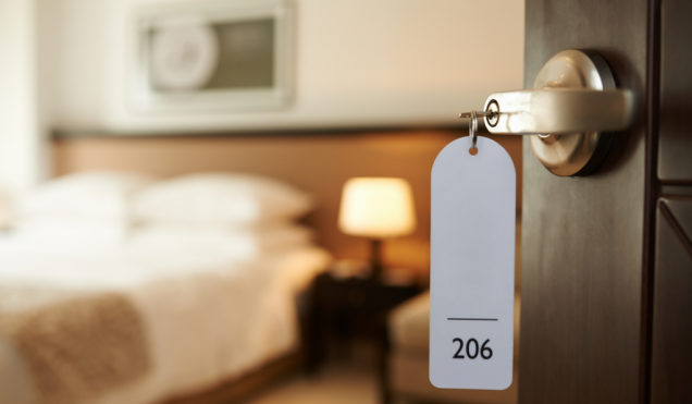 Open door of a hotel room with key in lock