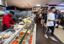 Fresh Food Co cook Jean St. Joy makes pizzas int he Warren Towers dining hall.