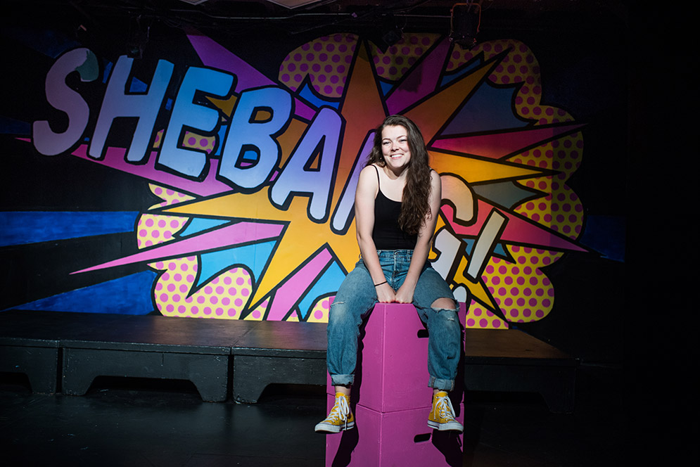 Actress and director Emily Brown (CFA’17), in front of a backdrop for a senior production she directed, plans to start a theater troupe with her award as soon as she finishes a yearlong tour.