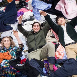 Students playfully toss cloths at the camera in the garment district