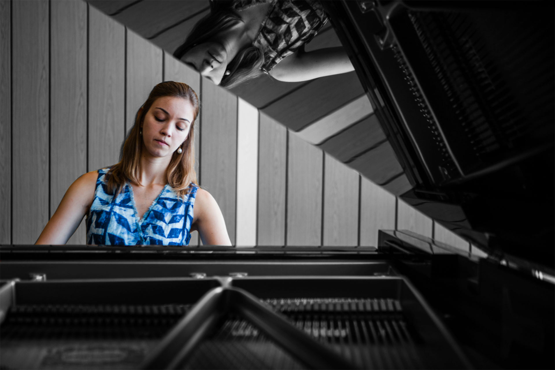 Bendada Music Festival founder Inês Andrade performs on a black grand piano.Photo taken from behind the piano looking at the performer.