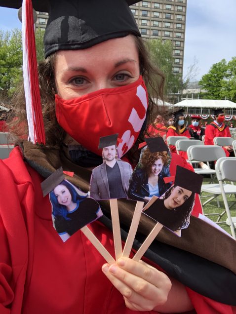 Bu Graduation, grad holding up photos of other grads