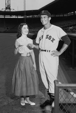 Pictured at Fenway Park on May 28, 1955, one month before his death, the Golden Greek presents the first Harry Agganis Scholarship, to Medford High School senior Cleopatra Sophios (SMG59). Photo by BU Photo Services