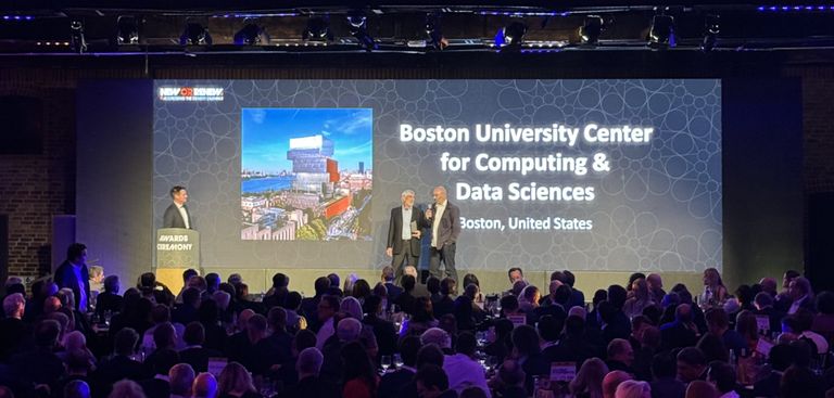 Photo of a stage and audience with a screen announcing the Boston University Center for Computing & Data Sciences winning the Best Tall Building Award 2024