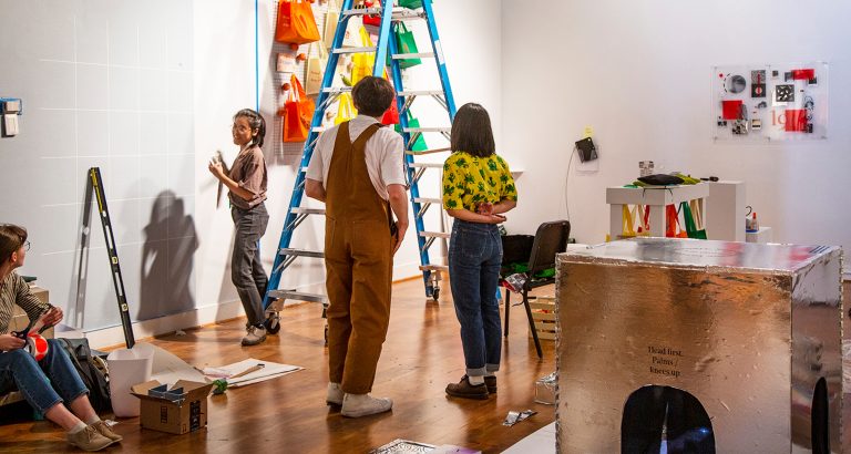 visual arts undergraduate students installing artwork in a gallery