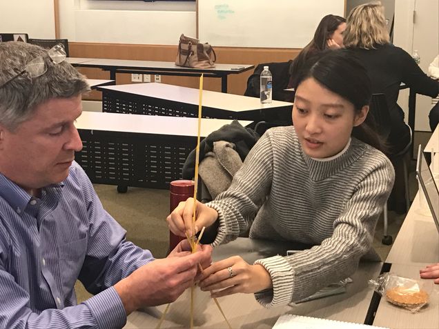 Richard LeBlanc (L) and Yi Ding (R) construct their spaghetti marshmallow tower during the Urban Symposium team building exercise.