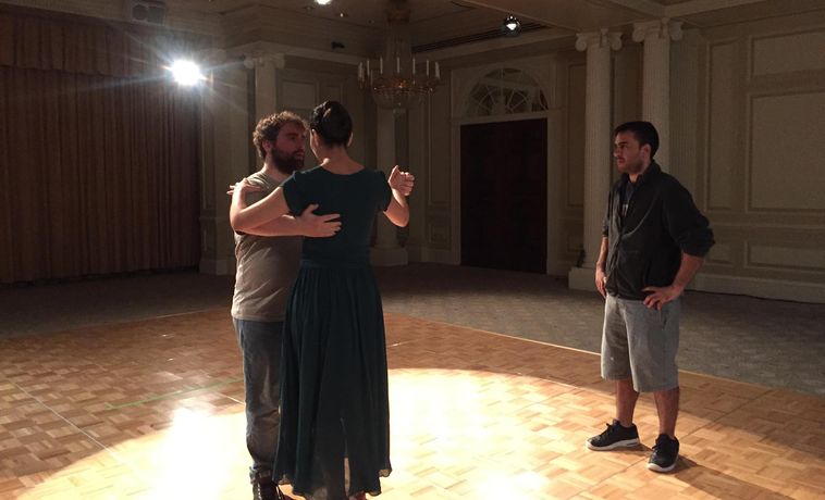 Young man and woman dancing in a empty ballroom scene