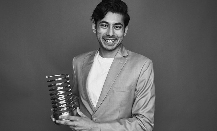 Rohan Gupta smiling portrait holding his Webby.