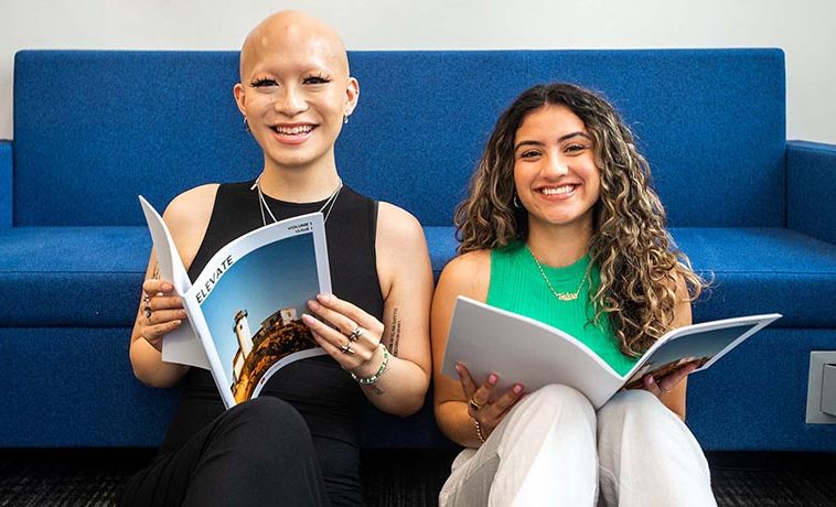 Kat Quach and Valerie Sanchez smiling while holding copies of Elevate magazine.