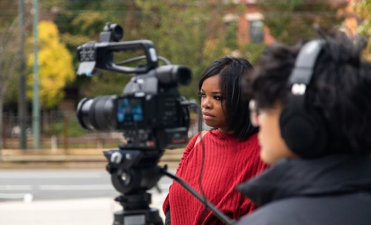 Man filming news story with woman