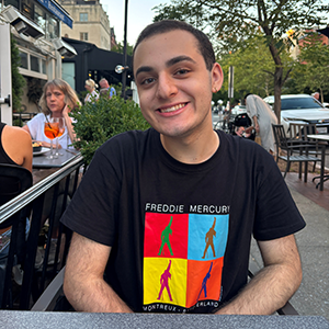 A joyful photo of Chase Pasekoff sitting at a desk.