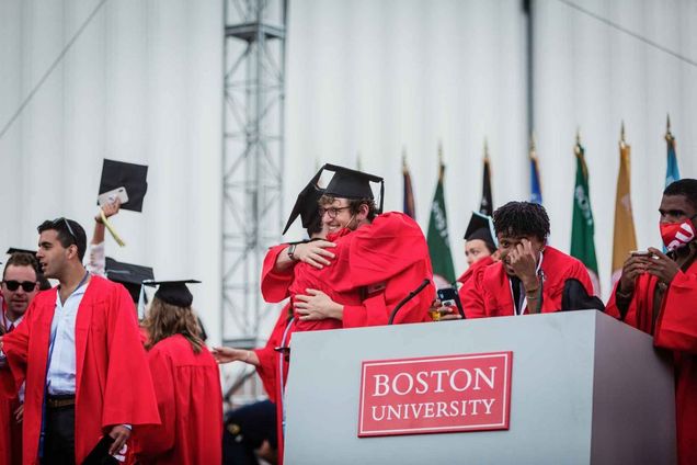 Graduates celebrate on the stage following the 2021 BU Commencement ceremony for undergraduate degrees