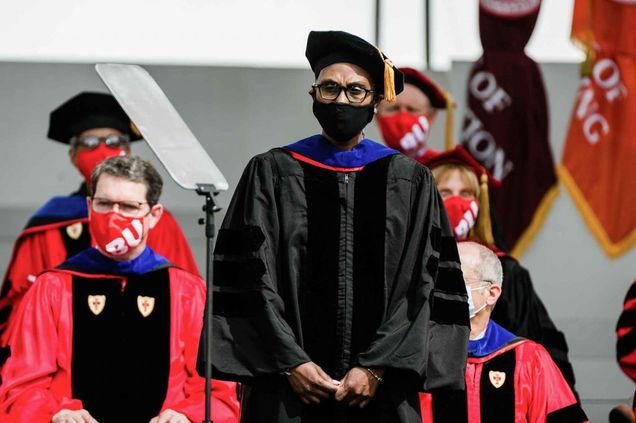 Fadie Coleman, School of Medicine assistant professor of medical sciences and education, stands while being awarded the Metcalf Award for Excellence in Teaching at the 2021 BU Commencement.