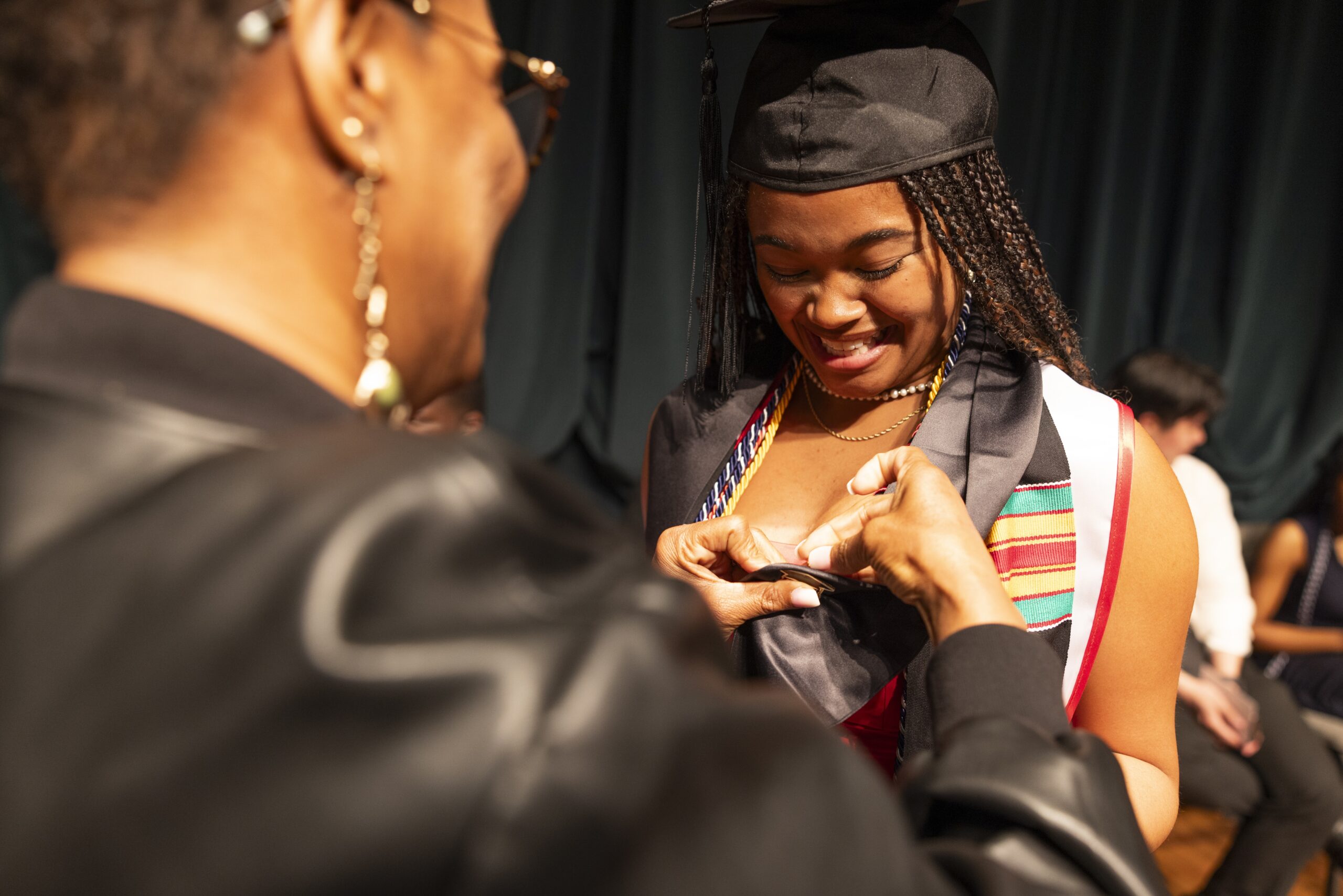 A student receiving a "Terrier F1RSTS" pin during the first-generation pinning ceremony