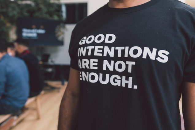 Person wearing a shirt stating: Good Intentions are not enough.